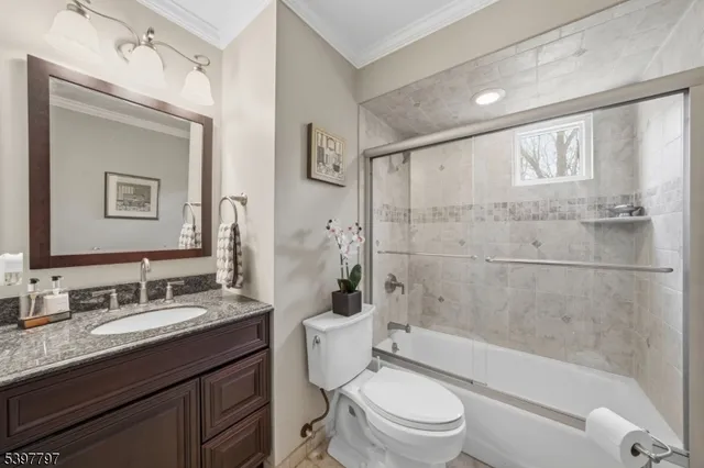 a bathroom with a granite countertop toilet a sink and a bathtub
