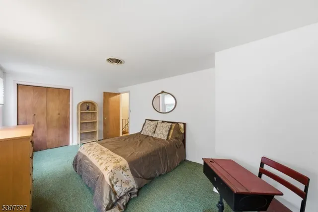 a bedroom with a bed and dresser with mirror