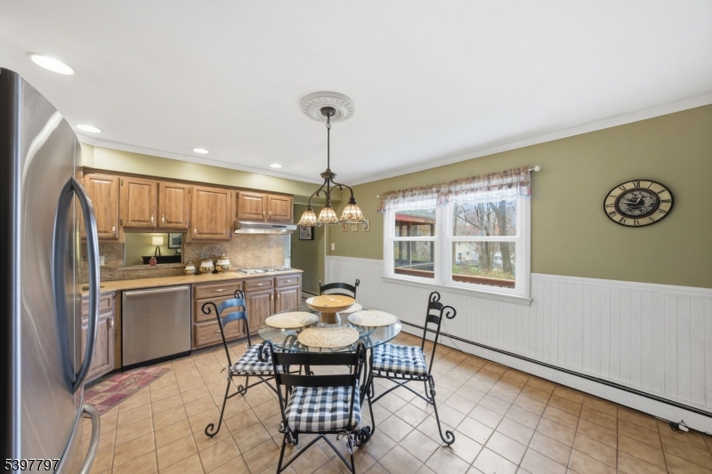 5 Glen Gate Road Boonton, NJ 07005 - Photo 6 of 46 a kitchen with stainless steel appliances granite countertop a stove a refrigerator a dining table and chairs with wooden floor