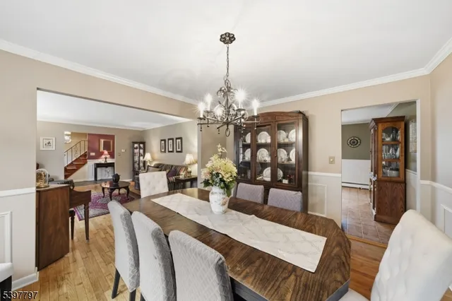 a view of a dining room with furniture a chandelier and wooden floor