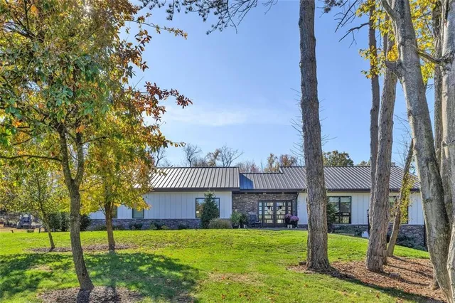 a view of a house with a yard and a tree