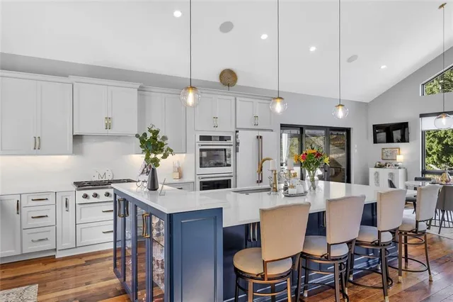 a kitchen with a dining table chairs stainless steel appliances and cabinets