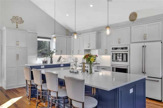 a kitchen with kitchen island a dining table and chairs