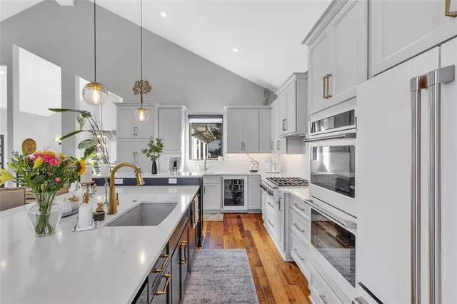 a kitchen with stainless steel appliances granite countertop a sink a stove and a refrigerator