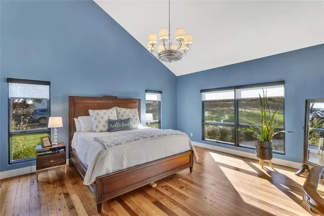 a bedroom with a large bed and a chandelier