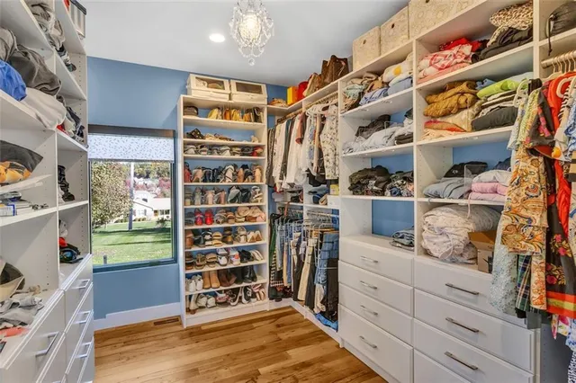 a view of walk in closet with clothes and shoes