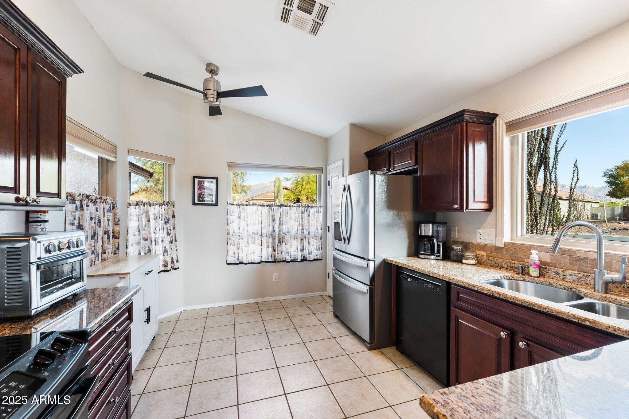 10363 East Rising Sun Place Gold Canyon, AZ 85118 - Photo 9 of 23 a kitchen with stainless steel appliances a sink stove refrigerator and cabinets