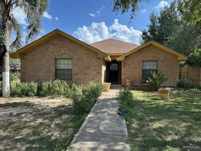 a front view of house with yard and trees around