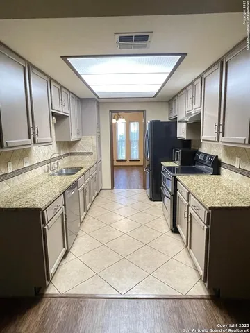 a large kitchen with stainless steel appliances granite countertop a stove sink and cabinets