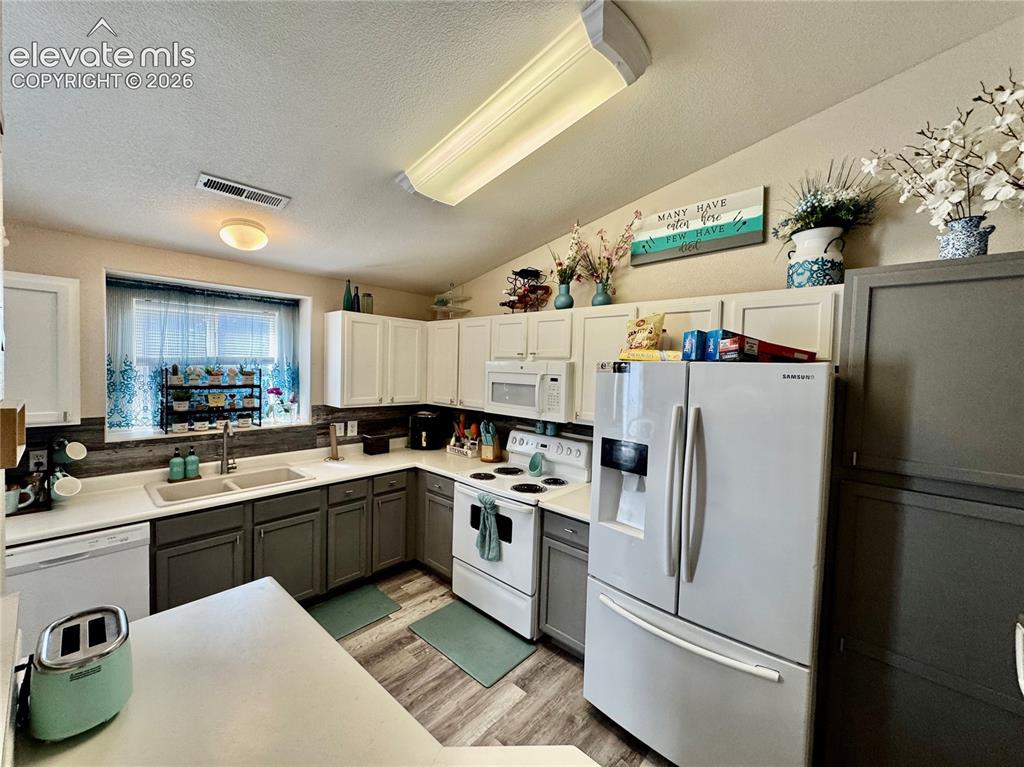 3748 Riviera Grove, Unit 203 Colorado Springs, CO 80922 - Photo 6 of 23 a kitchen with a sink a refrigerator and cabinets