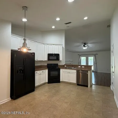 a large kitchen with a large counter top stainless steel appliances and cabinets