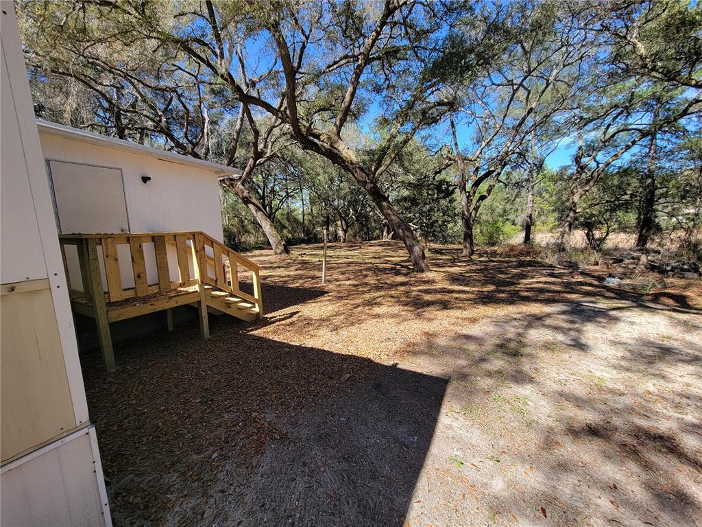 16625 Northeast 2nd Street Road Silver Springs, FL 34488 - Photo 2 of 9 a view of a yard with wooden fence and a fire pit
