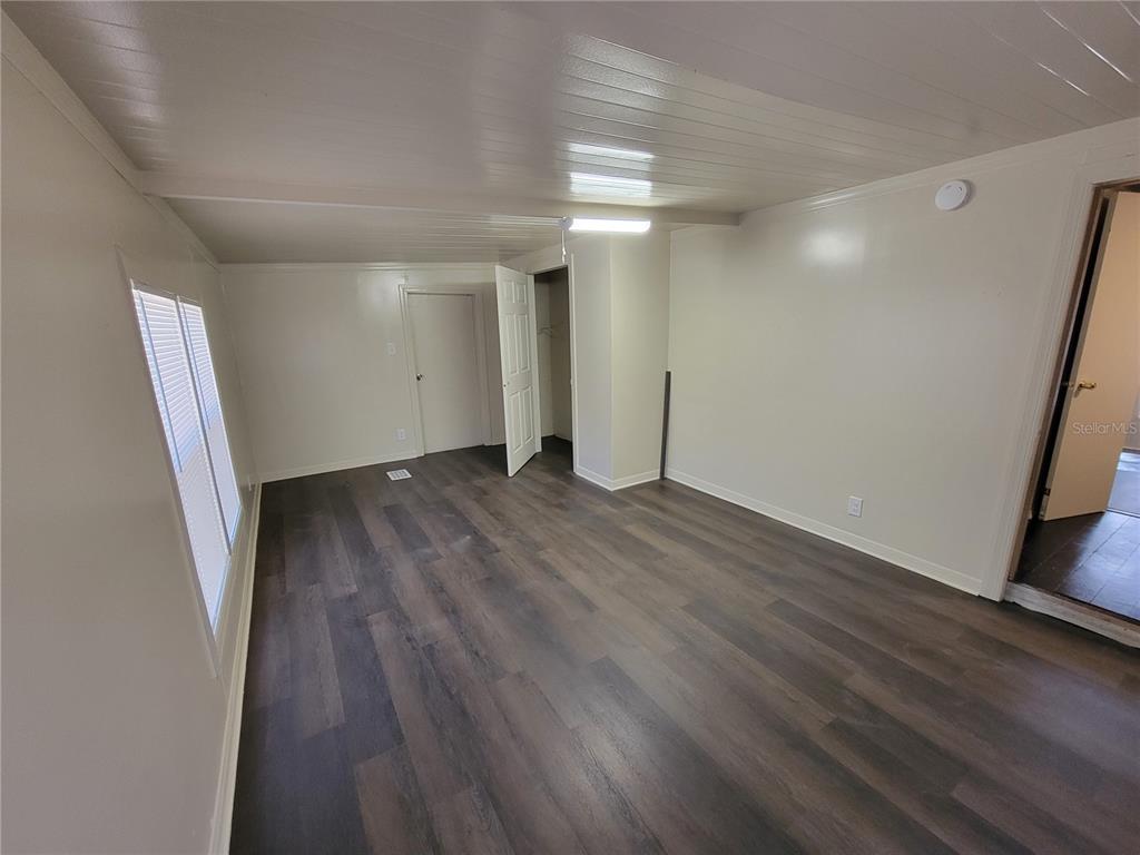 16625 Northeast 2nd Street Road Silver Springs, FL 34488 - Photo 5 of 9 an empty room with wooden floor and entrance