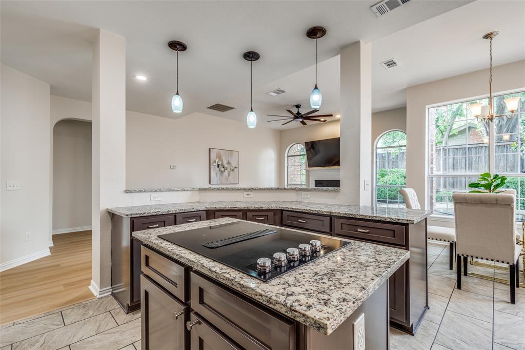 4037 Azure Lane Addison, TX 75001 - Photo 11 of 36 Kitchen with hanging light fixtures, a center island, dark brown cabinetry, a ceiling fan, and black electric stovetop