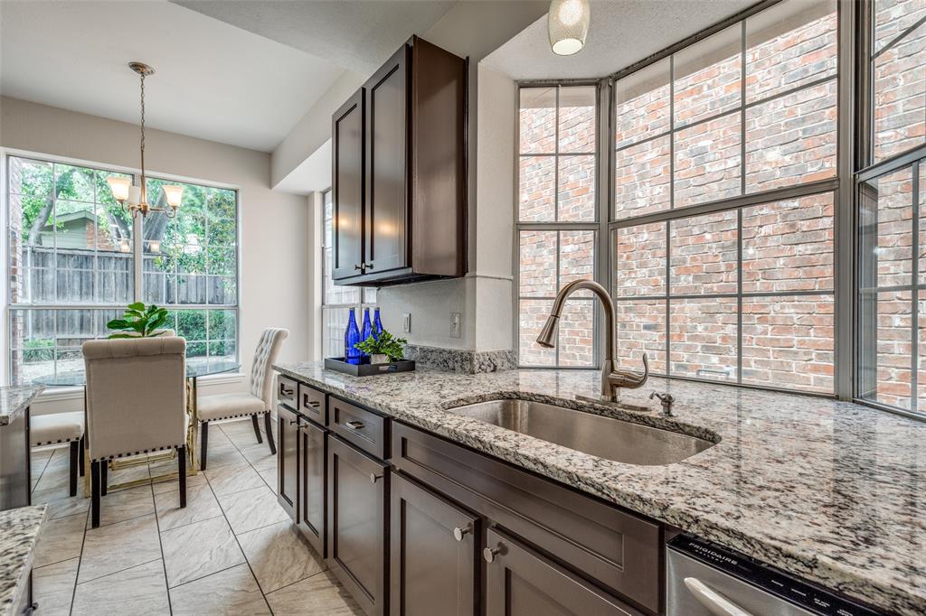 4037 Azure Lane Addison, TX 75001 - Photo 12 of 36 Kitchen with a chandelier, dark brown cabinetry, light stone countertops, pendant lighting, and stainless steel dishwasher