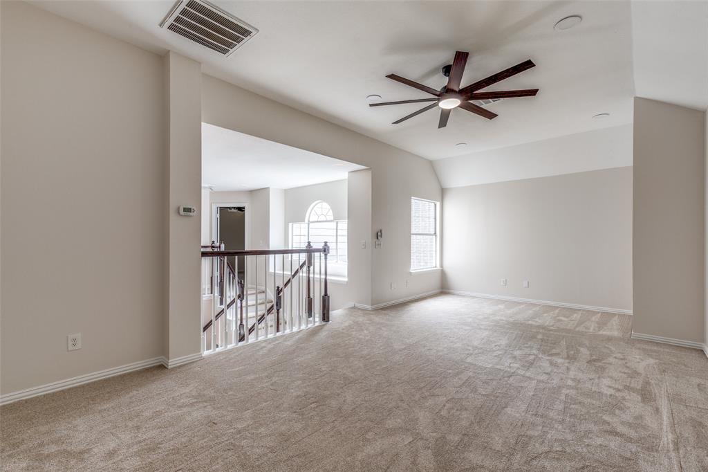 4037 Azure Lane Addison, TX 75001 - Photo 15 of 36 Unfurnished room with light carpet, a ceiling fan, and vaulted ceiling