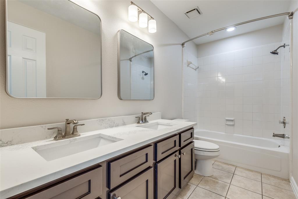 4037 Azure Lane Addison, TX 75001 - Photo 18 of 36 Bathroom with shower / bathtub combination, light tile patterned floors, and double vanity