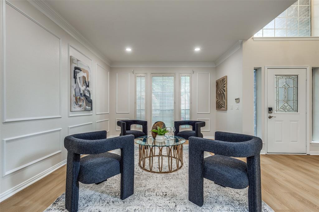 4037 Azure Lane Addison, TX 75001 - Photo 7 of 36 Living area with light wood finished floors, crown molding, recessed lighting, and a decorative wall