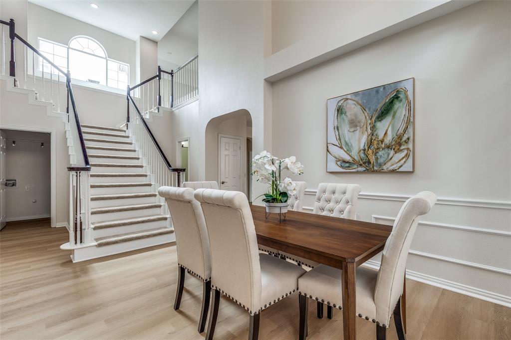 4037 Azure Lane Addison, TX 75001 - Photo 8 of 36 Dining space with arched walkways, stairs, light wood finished floors, and a towering ceiling