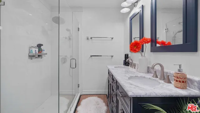 a bathroom with a granite countertop sink and a shower