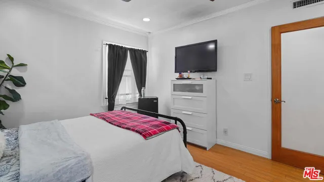 a bedroom with a bed and a flat screen tv