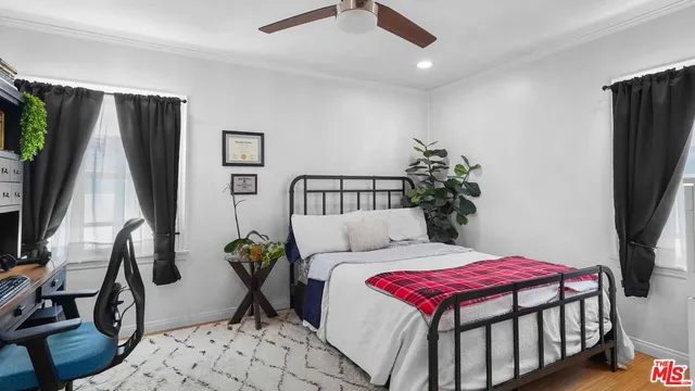 a bedroom with a bed a flat screen tv and a large dresser