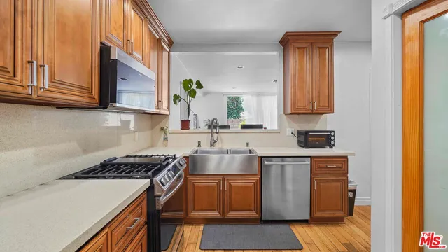 a kitchen with stainless steel appliances granite countertop a stove a sink and a microwave