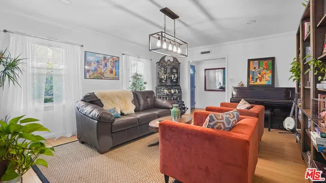 a living room with furniture a chandelier and a window