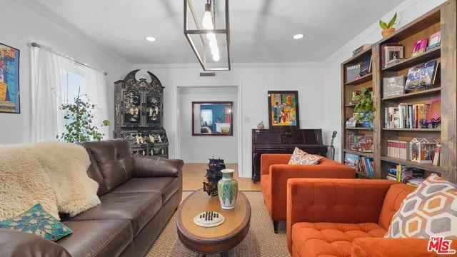 a living room with furniture and a book shelf