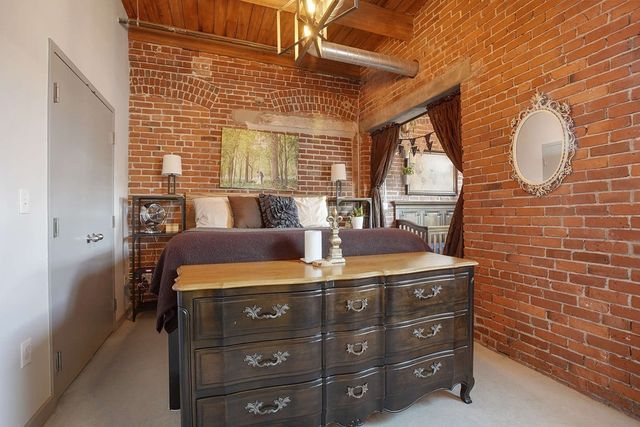 a bedroom with a bed and a large mirror on the dresser