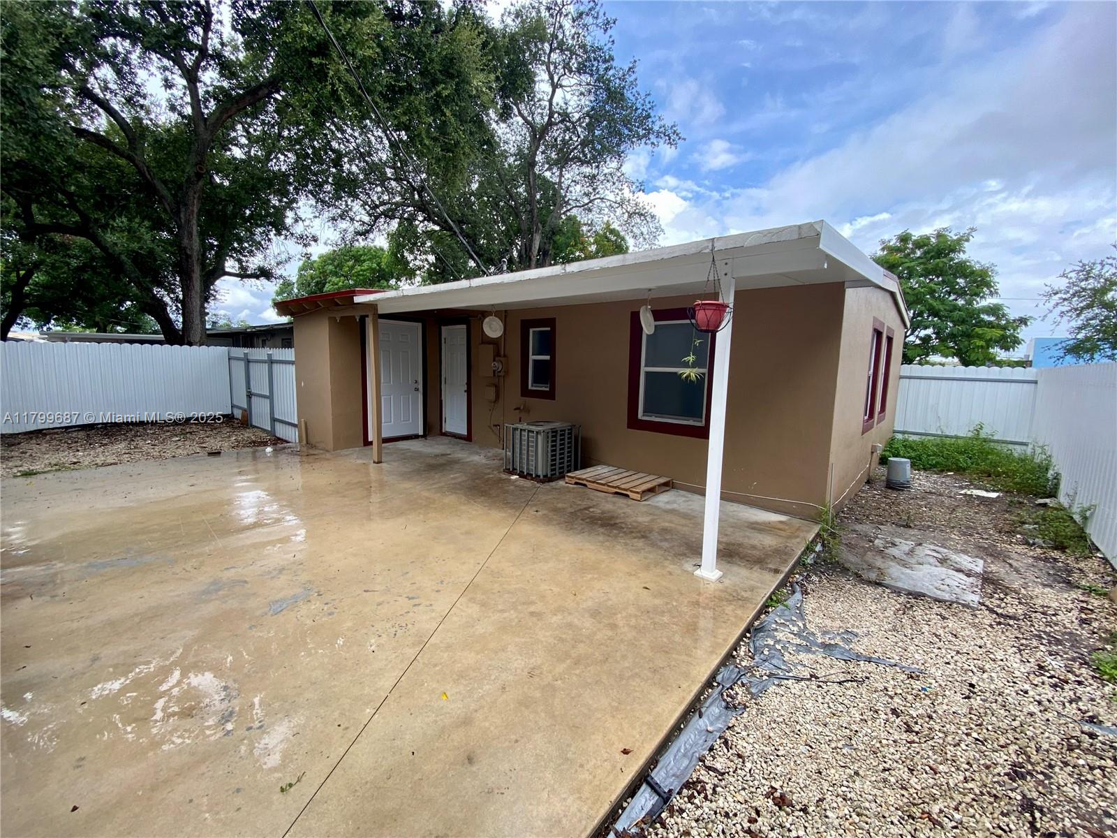 2340 Service Road Opa-Locka, FL 33054 - Photo 29 of 29 a view of a house with a patio and a yard