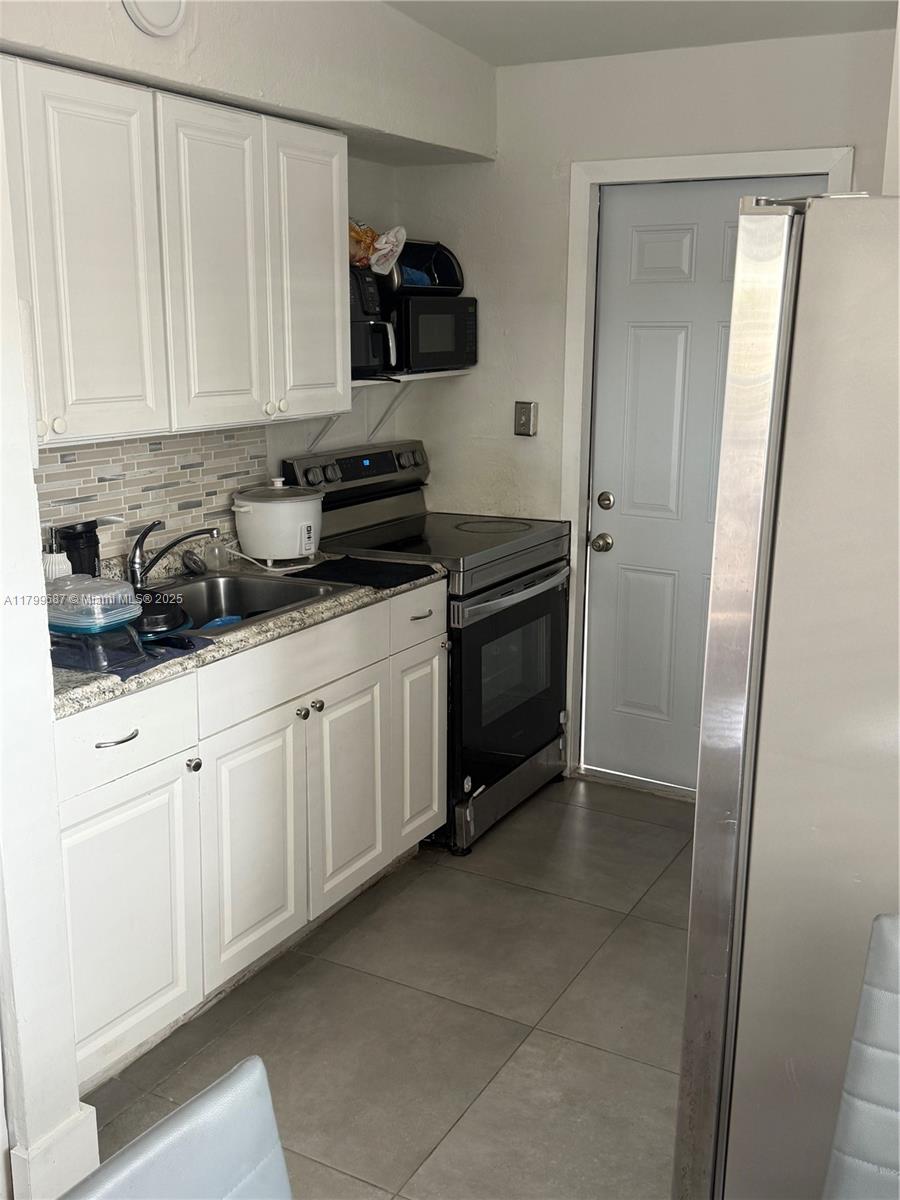 2340 Service Road Opa-Locka, FL 33054 - Photo 6 of 29 a kitchen with stainless steel appliances granite countertop a sink and a stove