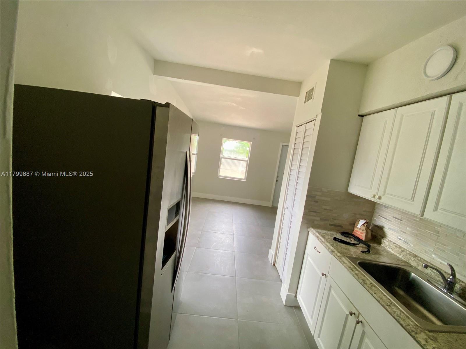 2340 Service Road Opa-Locka, FL 33054 - Photo 9 of 29 a kitchen with granite countertop a refrigerator and a sink