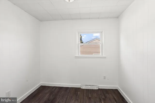 a view of a small space with wooden floor and a window