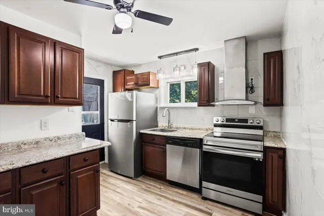 a kitchen with stainless steel appliances granite countertop a stove a refrigerator and a sink