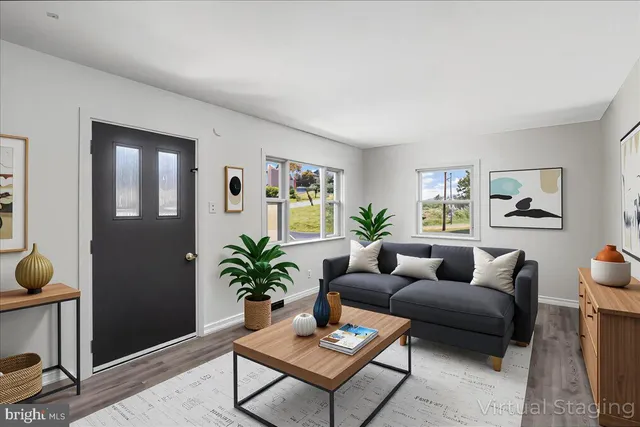 a living room with furniture a window and a potted plant