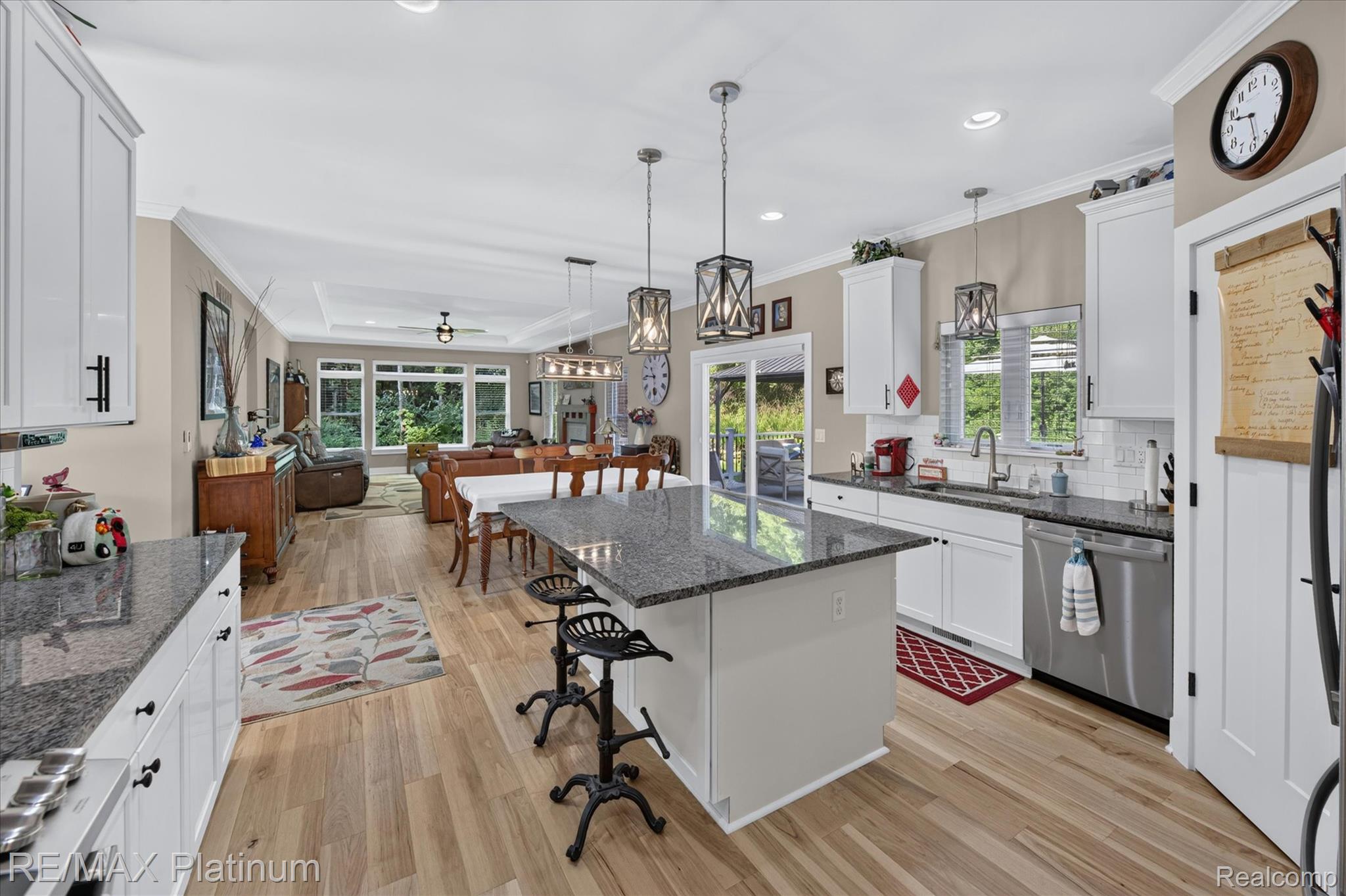 2676 Crooked Lake Road Howell, MI 48843 - Photo 16 of 60 Open-concept kitchen featuring an island with granite countertop, white cabinetry, stainless steel appliances, and wood-finish flooring