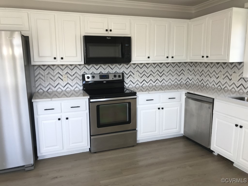 7235 Hopkins Road Richmond, VA 23237 - Photo 4 of 14 a kitchen with stainless steel appliances white cabinets and a stove a sink