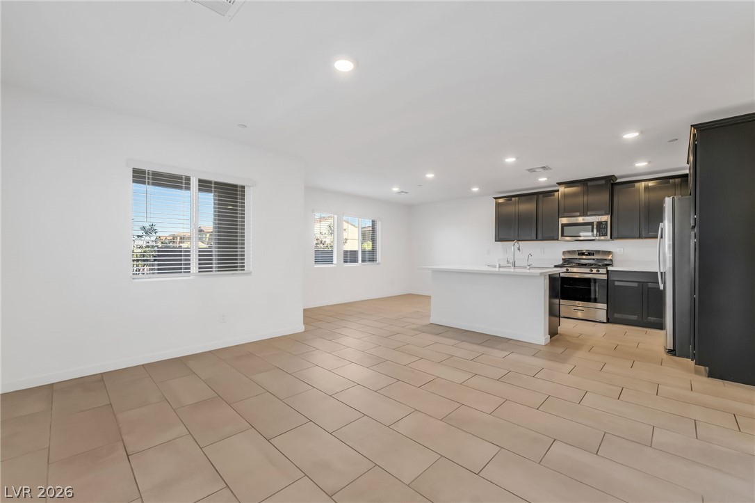 894 Cadence View Way Henderson, NV 89011 - Photo 6 of 23 A well-lit open-concept living area seamlessly connects to a contemporary kitchen with abundant cabinet space.