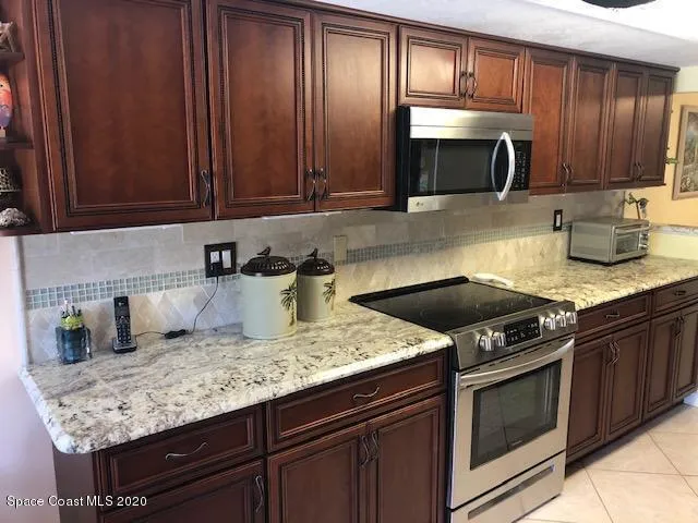 a kitchen with granite countertop stainless steel appliances a stove microwave and sink