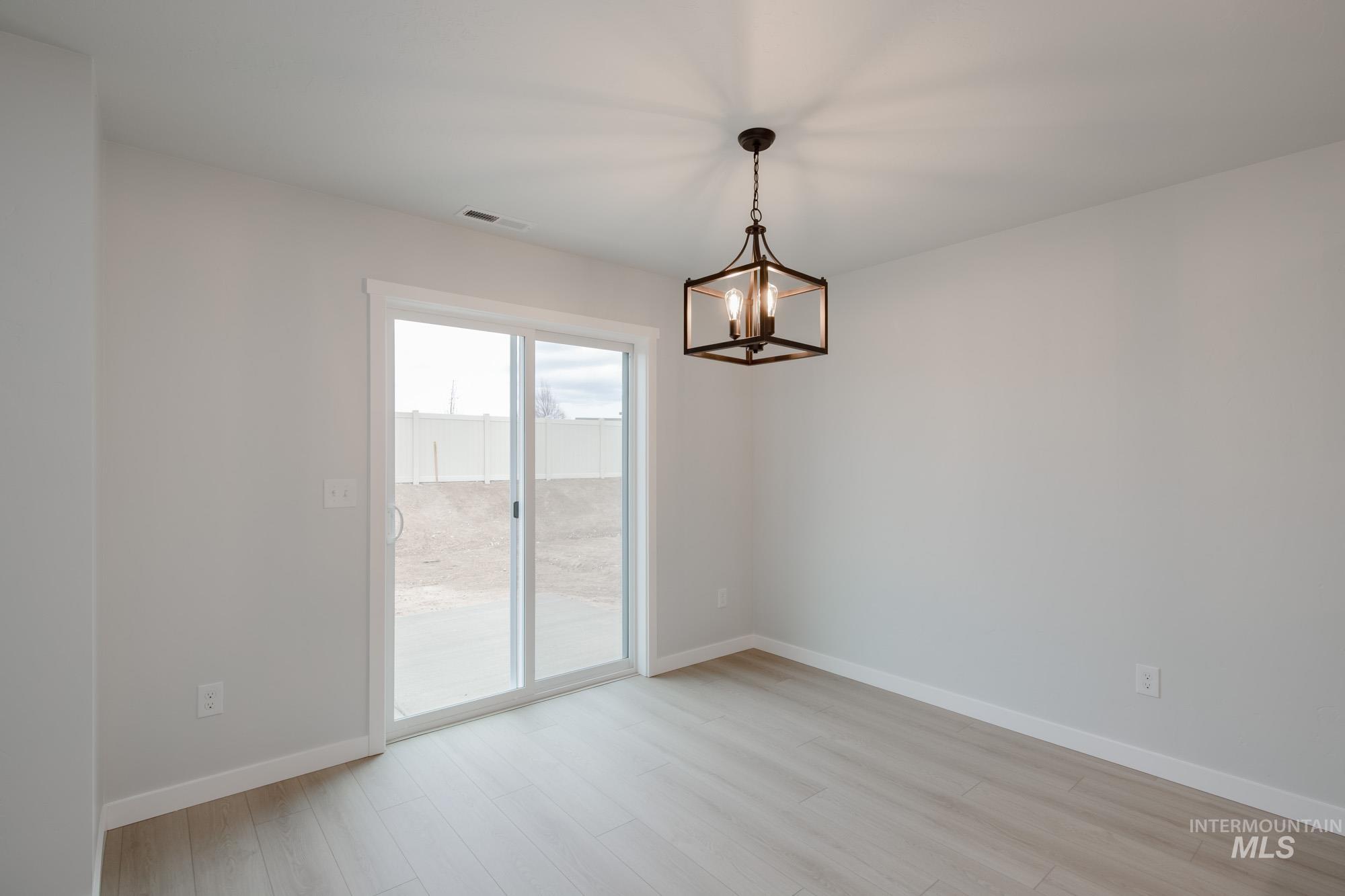 3005 South Maple Rnch Way Nampa, ID 83686 - Photo 11 of 25 Spare room featuring light wood-type flooring and a chandelier
