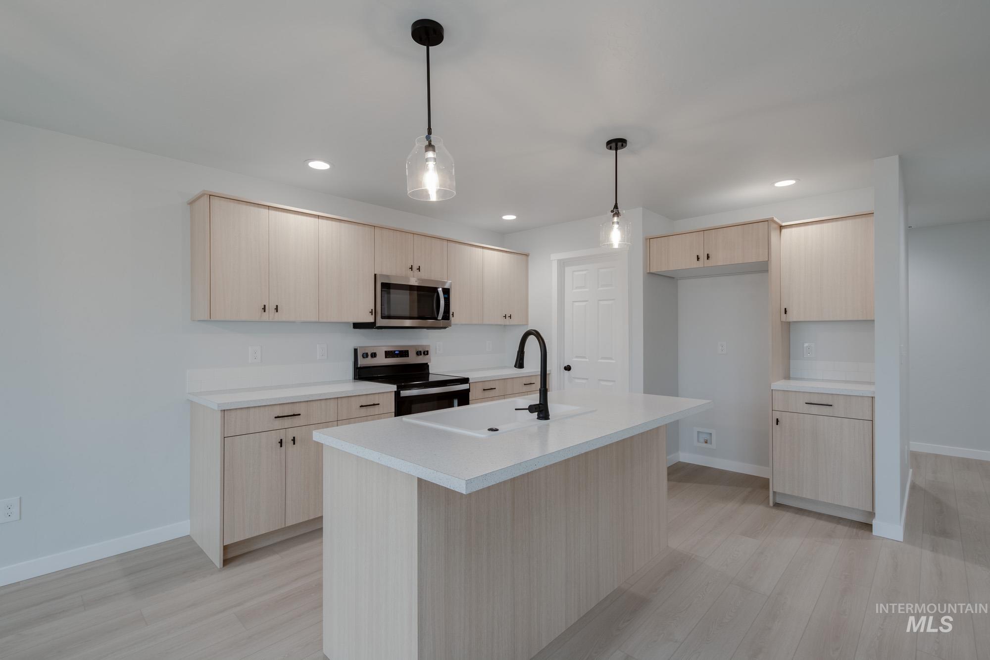 3005 South Maple Rnch Way Nampa, ID 83686 - Photo 6 of 25 Kitchen with light countertops, light brown cabinets, appliances with stainless steel finishes, pendant lighting, and recessed lighting