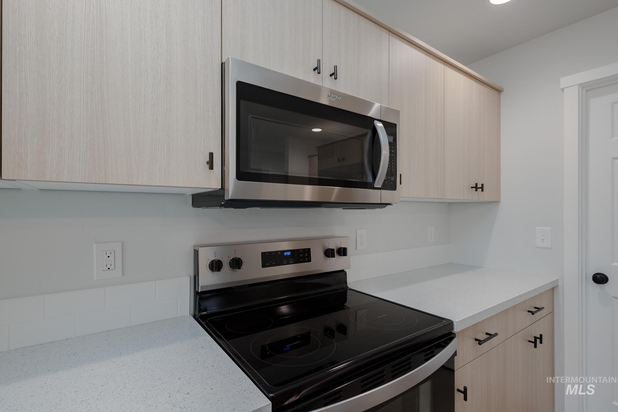 3005 South Maple Rnch Way Nampa, ID 83686 - Photo 9 of 25 Kitchen with light brown cabinets, stainless steel appliances, light stone counters, and modern cabinets