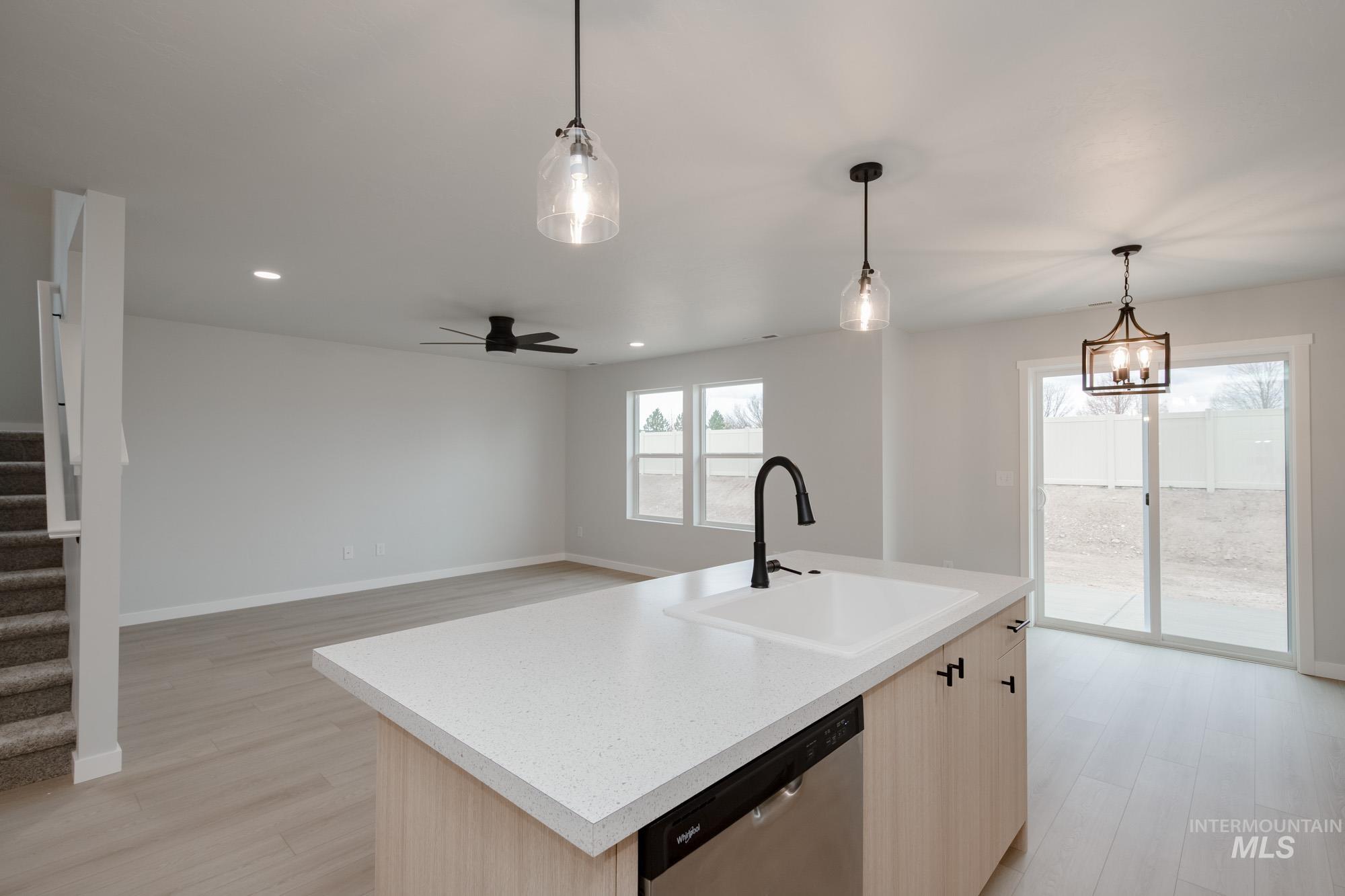 3005 South Maple Rnch Way Nampa, ID 83686 - Photo 10 of 25 Kitchen featuring light brown cabinets, hanging light fixtures, dishwasher, light wood-type flooring, and a kitchen island with sink
