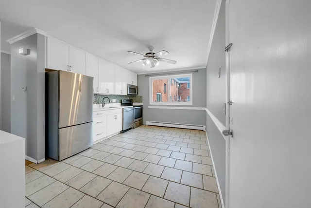 a kitchen with granite countertop a refrigerator and a stove top oven
