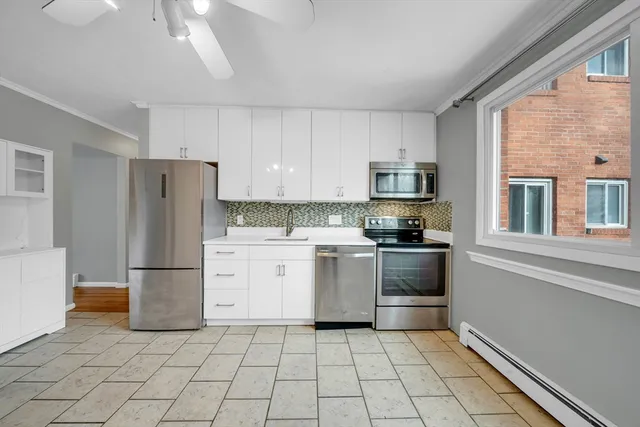 a kitchen with a refrigerator a stove top oven and a window