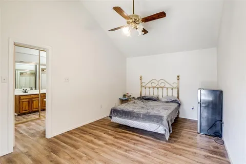 a bedroom with a bed and a mirror on the dresser