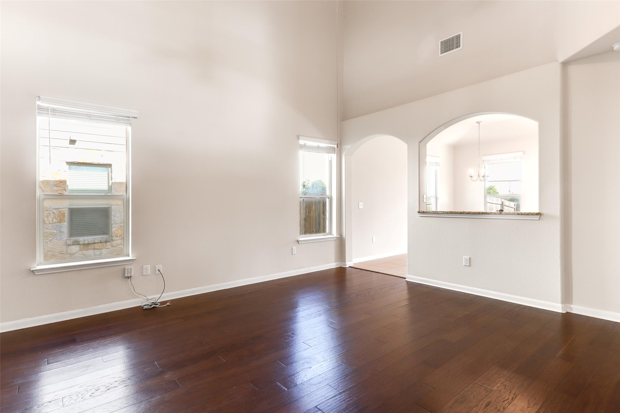 18705 Moreto Loop Pflugerville, TX 78660 - Photo 6 of 21 Rich hardwood floors complement soaring ceilings in this inviting open-concept living area.