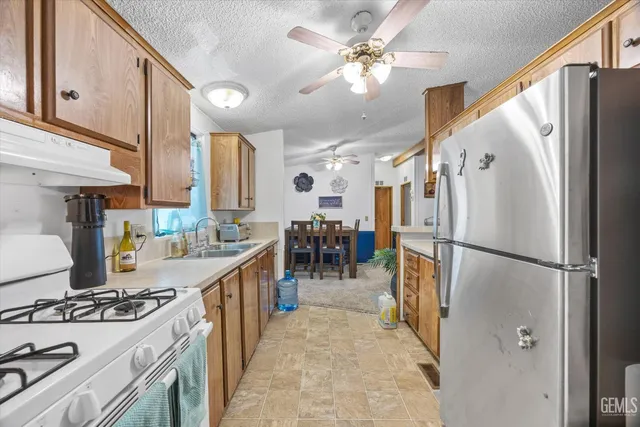 a kitchen with refrigerator a stove a sink and a refrigerator