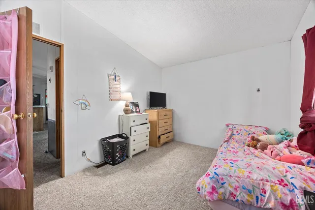 a bathroom with a granite countertop sink a toilet a mirror and shower curtain